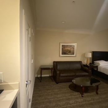 Ayres Hotel Orange - King suite. Coffee table, sofa, three bedside tables, desk, chair, tv closet, fridge, microwave and coffee maker included in this room - Hotels Near Me - Orange, California