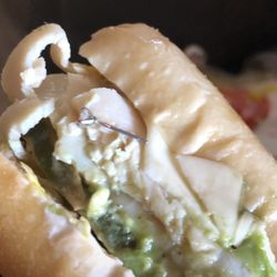 Deli Delicious - An earring on her turkey sandwhich. GROSS!