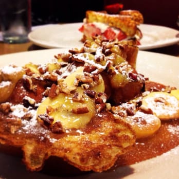 Kristof's Kafe - Banana caramel pecan French toast in the front, stuffed strawberry French toast in the back. - American Near Me - Davie, Florida