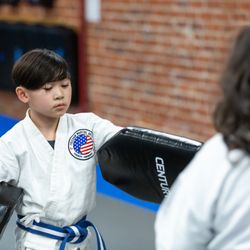 Freedom Martial Arts & Fitness, Inc. - Youth karate students hold targets for each other while working on striking techniques.