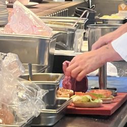 Culinaire Bazaar - This is the chef using one cutting board for everything including using the same blood stained dirty towel to wipe off both cutting boards.