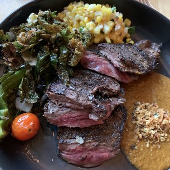 ATX Cocina - Skirt Steak is tender served with corn, Brussels sprouts and pumpkin mole. - Mexican Near Me - Austin, Texas