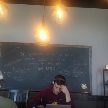 Einstein Bros Bagels - a man sitting at a table with a laptop - Bagels Near Me - Duluth, Minnesota