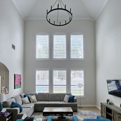 Budget Blinds of Southeast Austin and Hays County - Shutters add light control and beauty on the two story wall of this living room in Buda.
