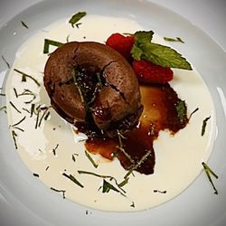 Chocolate Lava cake on a vanilla crème anglaise with fresh raspberries and a brown sugar Carmel sauce