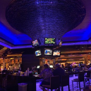 M Bar - a man sitting at a bar watching tvs - Lounges Near Me - Henderson, Nevada