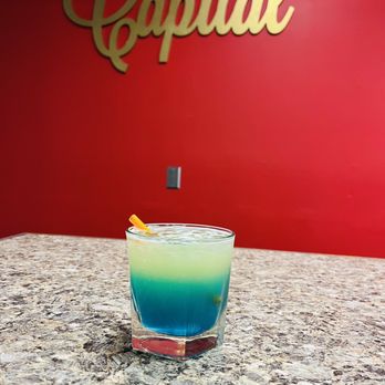 THE CAPITAL GRILLE & SEAFOOD - a blue and green cocktail - Seafood Near Me THE CAPITAL GRILLE & SEAFOOD - a blue and green cocktail - Seafood Near Me