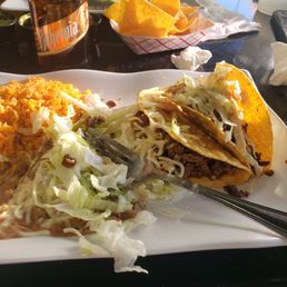 Crispy carna asada beef tacos with rice and beans.