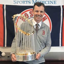 Riley & Han Dental Associates - Dr. Edwin Riley, IV holding the 2018 World Series Trophy when celebrating with other members of the Boston Red Sox Sports Medicine Team.