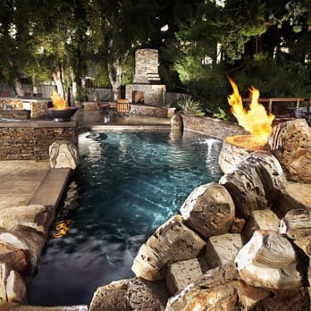 Infinity Pools - Pool and spa with artificial rock waterfall and slide, outdoor fireplace, and outdoor kitchen. - General Contractors Near Me - Costa Mesa, California Infinity Pools - Pool and spa with artificial rock waterfall and slide, outdoor fireplace, and outdoor kitchen. - General Contractors Near Me - Costa Mesa, California