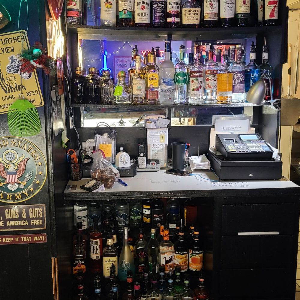 County Line Tap - a bar with liquor bottles and a neon sign - Sports Bars Near Me - Des Moines, Iowa