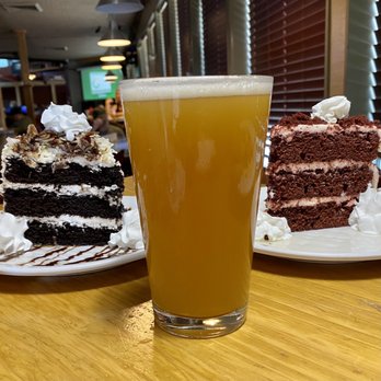 Bridge City Taproom - Indoor Survival Hazy IPA (6.5% abv / 35 ibu) from Everybody's Brewing (White Salmon, WA) flanked by 2 slices of cake - Sports Bars Near Me - Portland, Oregon Bridge City Taproom - Indoor Survival Hazy IPA (6.5% abv / 35 ibu) from Everybody's Brewing (White Salmon, WA) flanked by 2 slices of cake - Sports Bars Near Me - Portland, Oregon