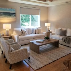 Rancho Interior Design - Comfortable, coastal living room in Carlsbad with custom sofas, beautiful area rug, tables lamps, textured wallpaper and original art.