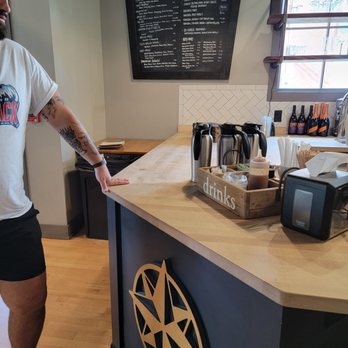 Wayfarer Coffee Roasters - a man standing in front of a counter - Coffee & Tea Near Me - Laconia, New Hampshire Wayfarer Coffee Roasters - a man standing in front of a counter - Coffee & Tea Near Me - Laconia, New Hampshire