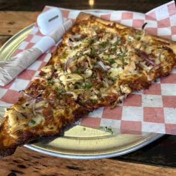 Decent Pizza - BBQ chicken pizza slice and AirPods Pro for size context. - Pizza Near Me - Tallahassee, Florida