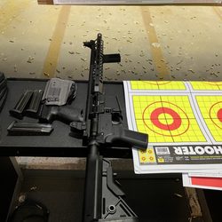 On Target Sports - Unloaded rifle and handgun in its holster on the shooting lane table at OTS.