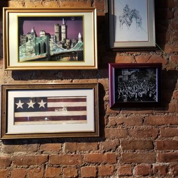 Spikes - a brick wall with a bunch of pictures on it - Bars Near Me - New York, New York