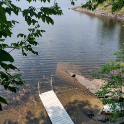 SunderLand Cottages - The Chickadee Cottage lakefront: the dock, the rock, and the views invite you to enjoy the quiet cove,  visiting loons, and lake adventures!