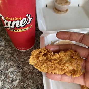 Raising Cane’s Chicken Fingers - a hand holding a fried chicken - Fast Food Near Me - Richmond, Texas