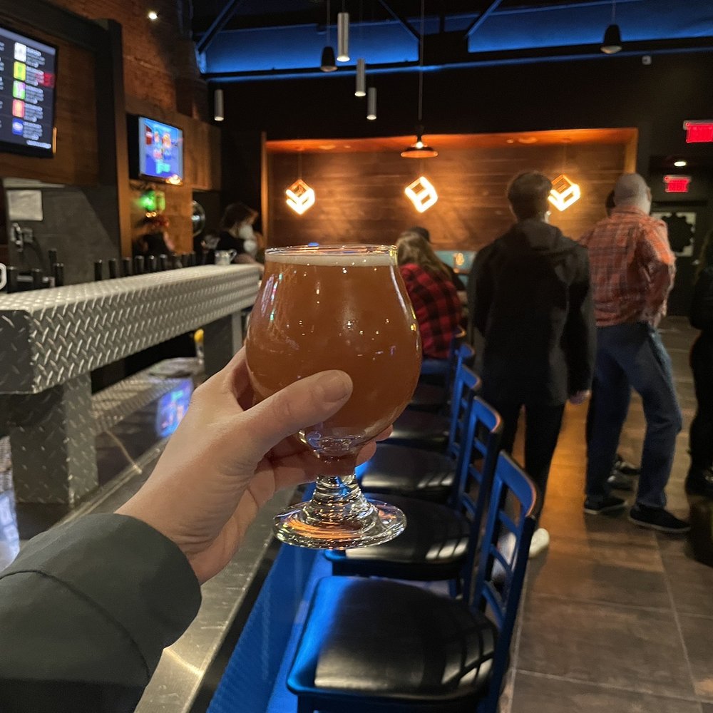 Bit Bar Salem - a person holding a glass of beer - Bars Near Me - Salem, Massachusetts Bit Bar Salem - a person holding a glass of beer - Bars Near Me - Salem, Massachusetts