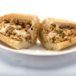 Genova's To Go - A mouthwatering chicken cheesesteak sandwich on a plate - Genova's To Go's specialty!