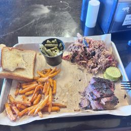 Meat plate with brisket and pulled pork sides of sweet potato fries and green beans Meat plate with brisket and pulled pork sides of sweet potato fries and green beans