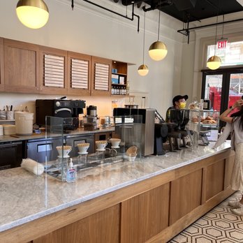 Blue Bottle Coffee - The Walker - a woman standing at a counter in a coffee shop - Coffee & Tea Near Me - New York, New York