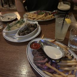 steak and fries with the cream sauce and chimichurri across the table