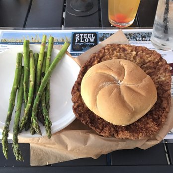 Steel Plow Burger - Breaded pork tenderloin with side of asparagus. - Burgers Near Me - Moline, Illinois Steel Plow Burger - Breaded pork tenderloin with side of asparagus. - Burgers Near Me - Moline, Illinois