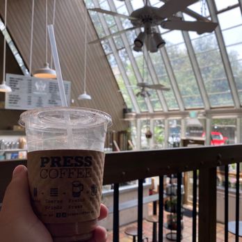 PRESS Coffee - Iced Mocha Chai Latte and views from within a coffee shop converted from a greenhouse. - Coffee & Tea Near Me - San Antonio, Texas PRESS Coffee - Iced Mocha Chai Latte and views from within a coffee shop converted from a greenhouse. - Coffee & Tea Near Me - San Antonio, Texas