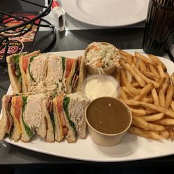 Pizzeria 67 - Club 4 étages, a Club sandwich served with Fries and gravy, as well as mayo and coleslaw.