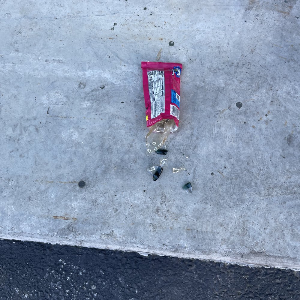 Extra Space Storage - This is by their loading door.  Broken glass and candy wrapper. - Self Storage Near Me - Santa Cruz, California