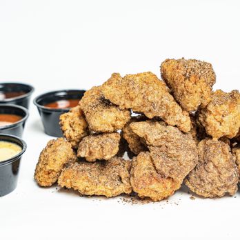 Tyga Bites - a pile of fried chicken with dipping sauces - Comfort Food Near Me Tyga Bites - a pile of fried chicken with dipping sauces - Comfort Food Near Me