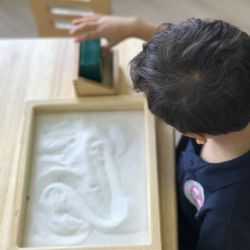 Cornus Montessori - Using sandpaper numbers and a sand tray to practice our writing skills!