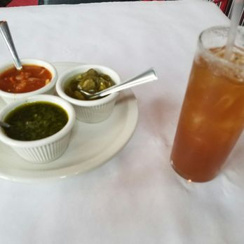 Fritanga - Array of sauces and peppers, with a Rumtarindo cocktail - Latin American Near Me - Saint Louis, Missouri Fritanga - Array of sauces and peppers, with a Rumtarindo cocktail - Latin American Near Me - Saint Louis, Missouri