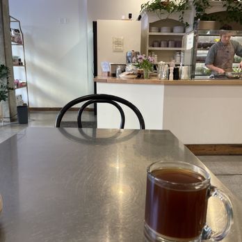 Basal - a cup of coffee on a table in a coffee shop - Salad Near Me - Missoula, Montana