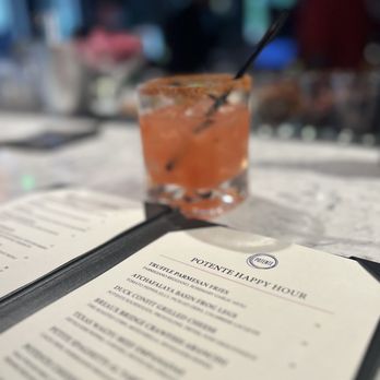 Potente - a drink and menu on a table - Italian Near Me - Houston, Texas Potente - a drink and menu on a table - Italian Near Me - Houston, Texas