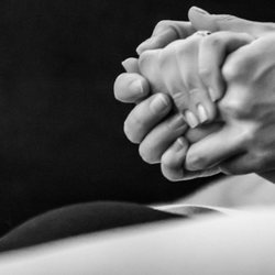 O‘ahu Birth Doula - Teresa Robertson - Birth Doula and partner hold a woman's hand during childbirth.