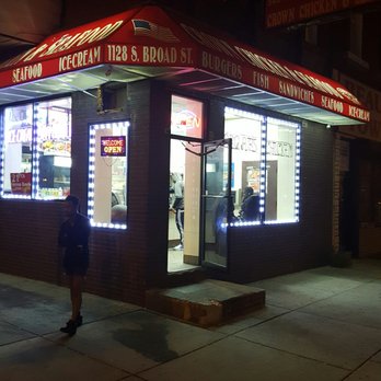 Crown Fried Chicken - a woman walking in front of a restaurant - Fast Food Near Me - Philadelphia, Pennsylvania