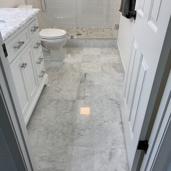 Creative Tile Services - a bathroom with a marble floor - General Contractors Near Me