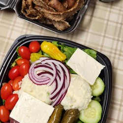 Big chunks of feta and potato salad on top of the Greek salad