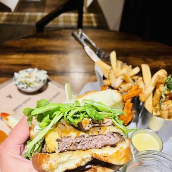 Burgers and Bourbon - a hand holding a sandwich - Burgers Near Me - Park City, Utah