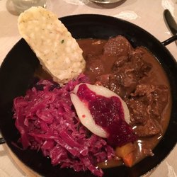 Keintzel - Hirschragout mit Serviettenknödel, Blaukraut, Birne vom Kompott und Preiselbeermarmelade. Im Original RIESS-Pfandl