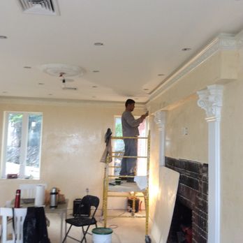 JNH Construction - a man on a ladder painting a room - General Contractors Near Me - Brooklyn, New York