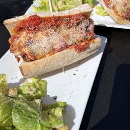 Meatball sandwich with side of Ceasar salad.