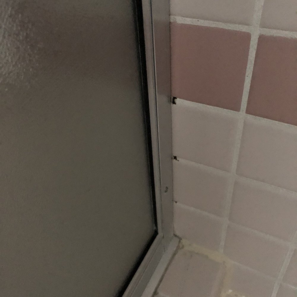 Shower with dark spots on white grout Shower with dark spots on white grout