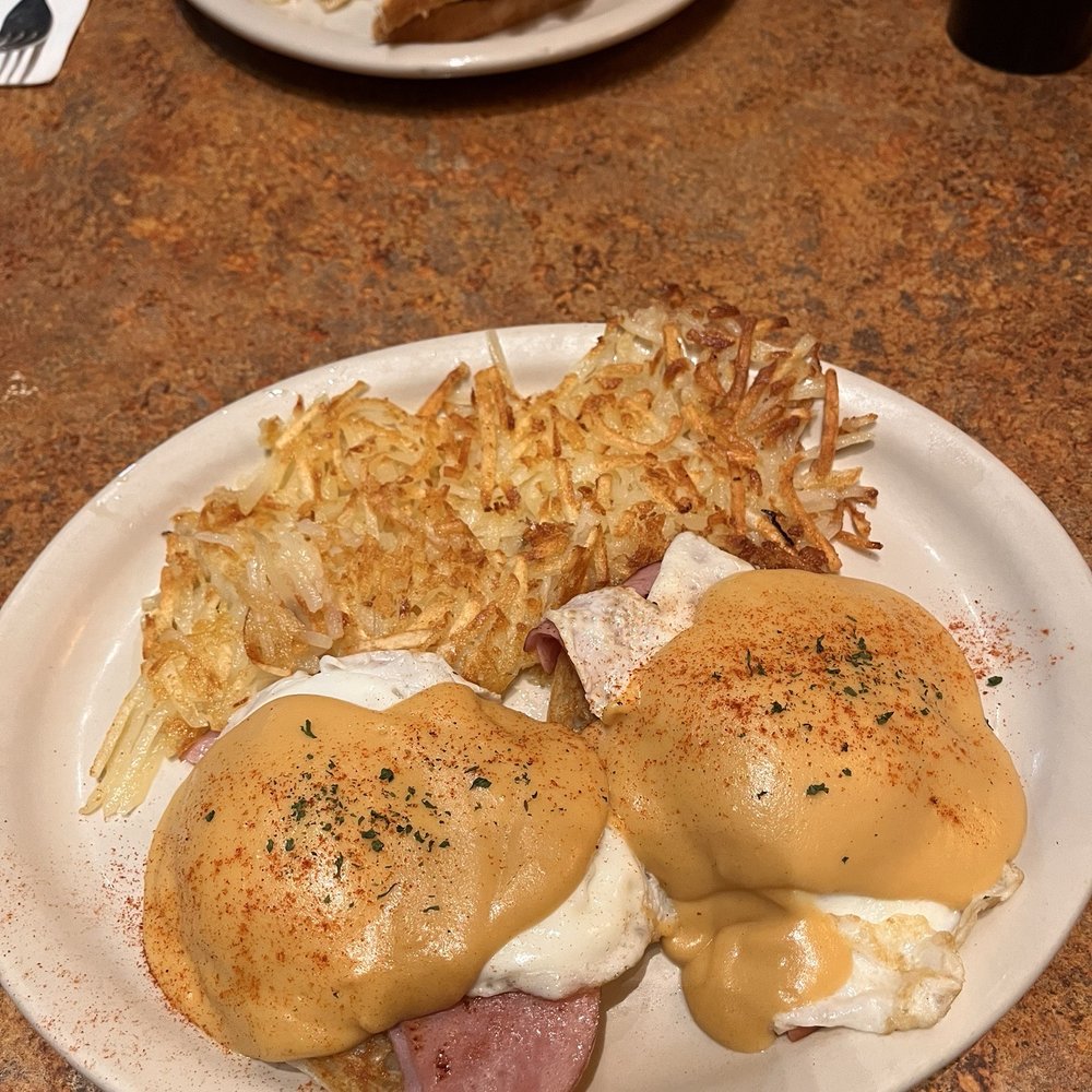Eggs Benedict with breakfast sandwich in the bg