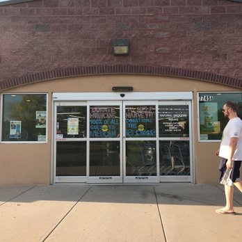 Natural Grocers - a man walking in front of a store - Grocery Near Me - Arvada, Colorado