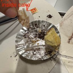 I was chewing on my tiramisu cheesecake and this was in the bite. It doesn't resemble any of the packaging. 12/07/2025. I was chewing on my tiramisu cheesecake and this was in the bite. It doesn't resemble any of the packaging. 12/07/2025.