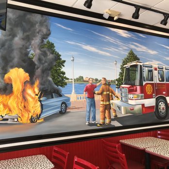 Firehouse Subs - Firehouse mural depicting car on fire at Lake Mirror and bystander & Firemen not very concerned by it all. Lol - Sandwiches Near Me - Lakeland, Florida